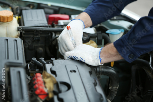 Mechanic hands in gloves repairing car in open hood