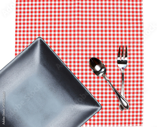 Top view plate with fork and spoon on tablecloth for food servin photo