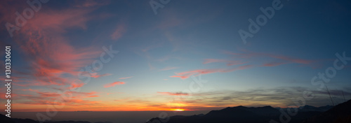 Fiery sunset from mountain pick with thin glazes in the sky evening. Fall season. Orobie alps. Rena pick. Bergamo Italy. In the distance the Monviso.