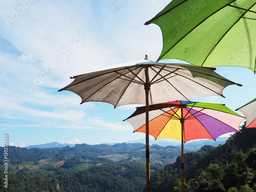 Close up colorful umbrellas over mountains and blue sky