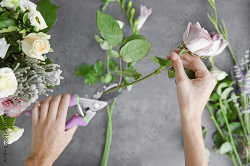 Female florist making beautiful bouquet at flower shop
