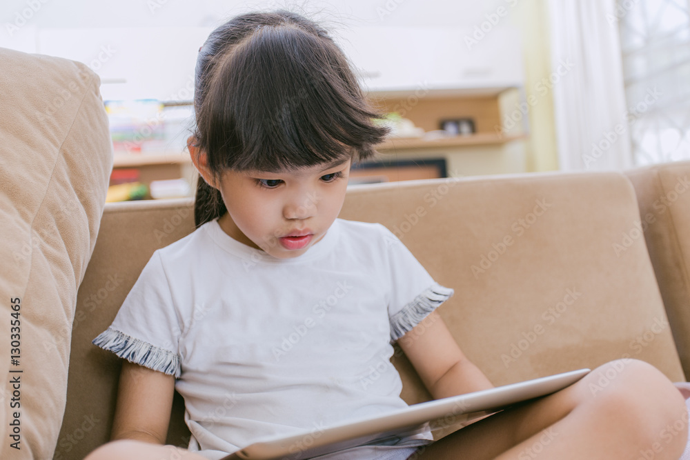 Children play Tablet on living room at home Children play Tablet on living room at home