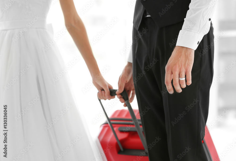 Groom and bride with big suitcase indoors Groom and bride with big suitcase indoors