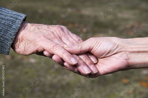 介護する老人と娘の手のアップ © norinori303