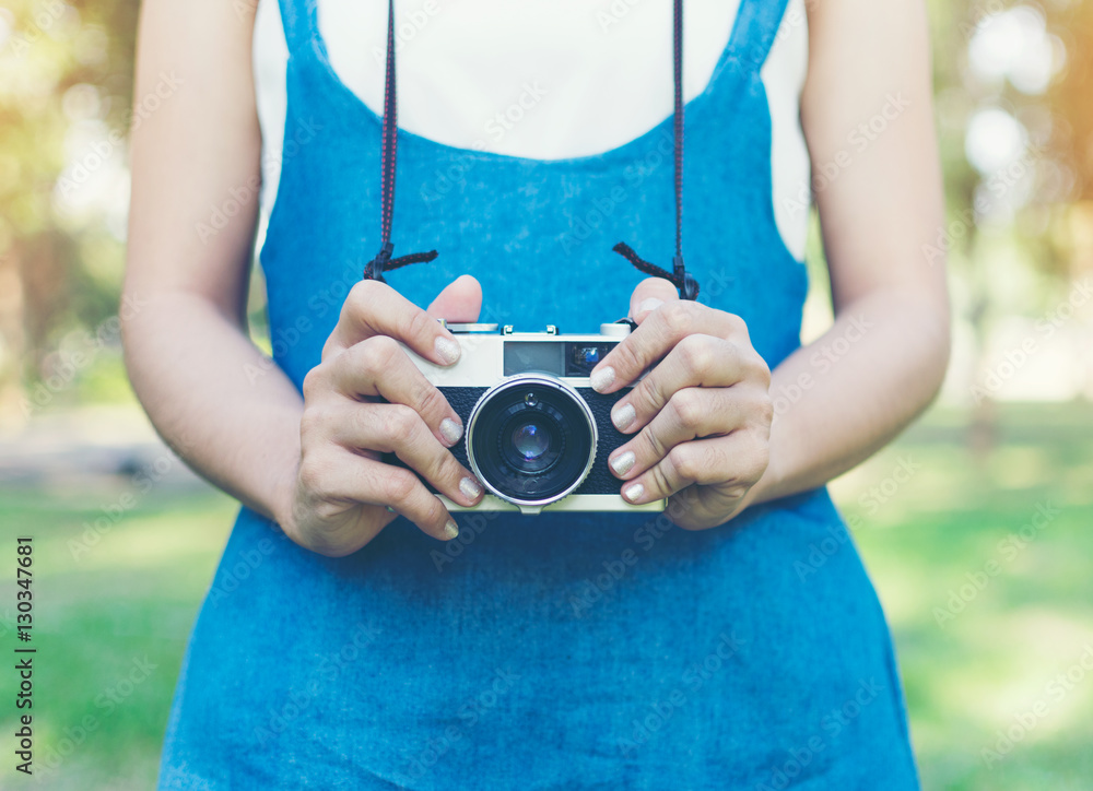 Fototapeta premium vintage autumn photo with girl standing in a park with old camera.