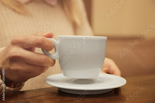 Woman holding cup of coffee, closeup