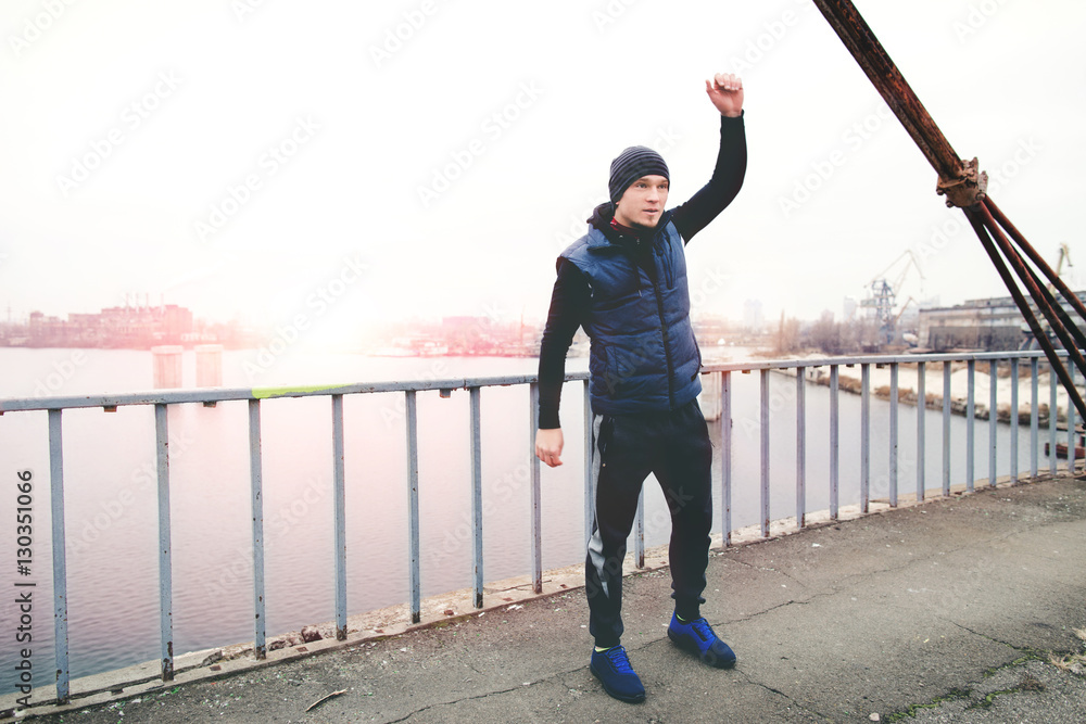 athlete warming up before training on a city bridge