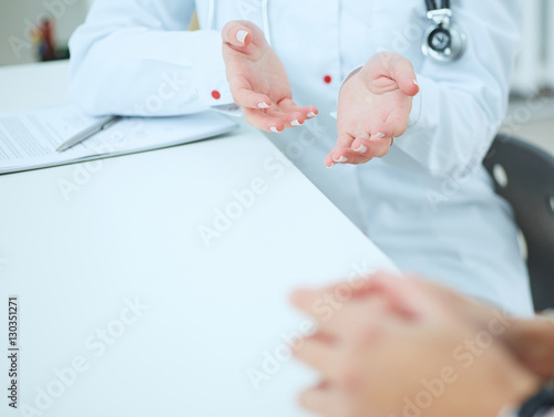 Doctor and patient are discussing something, just hands at the table.
