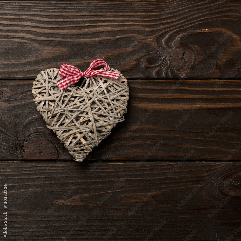 Concept of Valentine's Day. Wicker hearts on dark wooden backgro Concept of Valentine's Day. Wicker hearts on dark wooden backgro