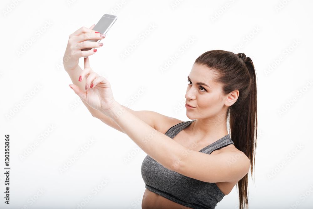 Pretty brunette sports woman taking selfie with her mobile phone Pretty brunette sports woman taking selfie with her mobile phone