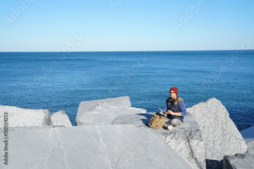 фотографія Young reporter connected on tablet by the ocean