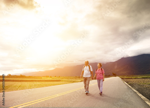 senior couple hiking on the country road