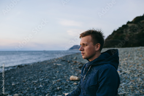 man sitting on the beach and looking forward © skvalval