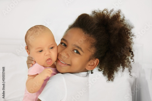 Girl holding her little sis...