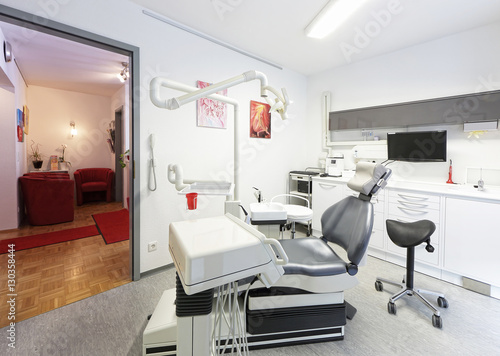 Modernes Behandlungszimmer beim Zahnarzt mit Wartezimmer im Hintergrund 