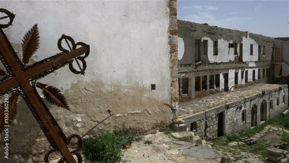 Burnt and rusted metal cross in ruins of old orthodox monastery. Burnt and rusted metal cross in ruins of old orthodox monastery.