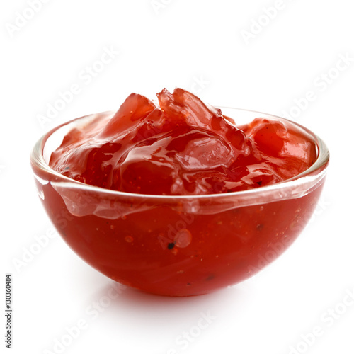 Red onion chutney in glass bowl isolated on white.