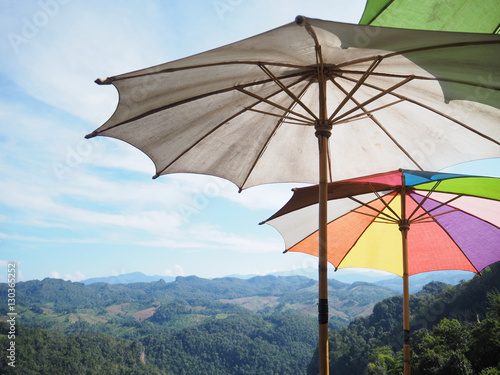Close up colorful umbrellas over mountains and blue sky