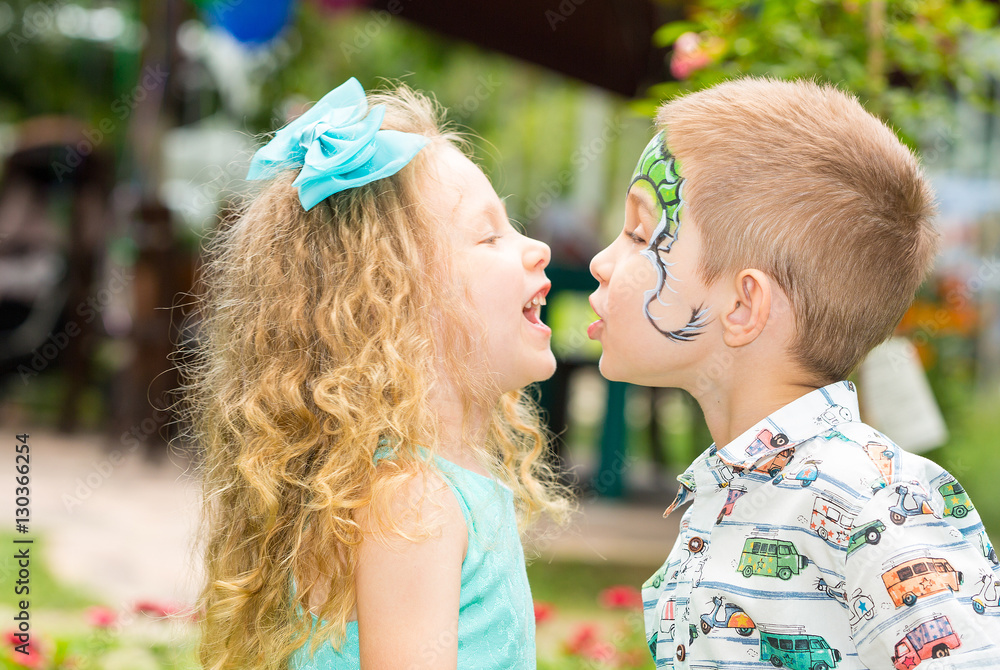 The boy and girl child with aqua make-up on happy birthday. Celebration concept and childhood, love The boy and girl child with aqua make-up on happy birthday. Celebration concept and childhood, love