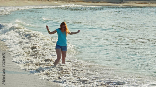Young woman with long red hair play waves, seascape beach of Dominican Republic