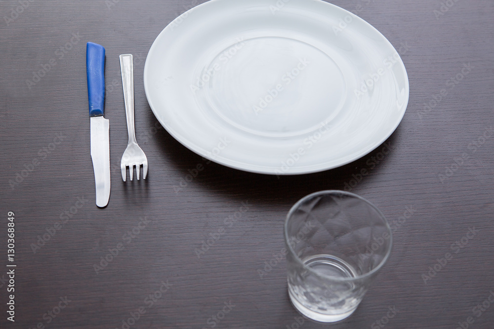 piatto, forchetta, coltello e bicchiere su tavola