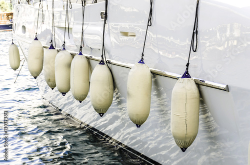 Modern yacht fenders attached with ropes.