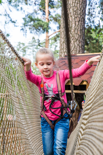 Little girl on a playground. Child playing outdoors in summer. 