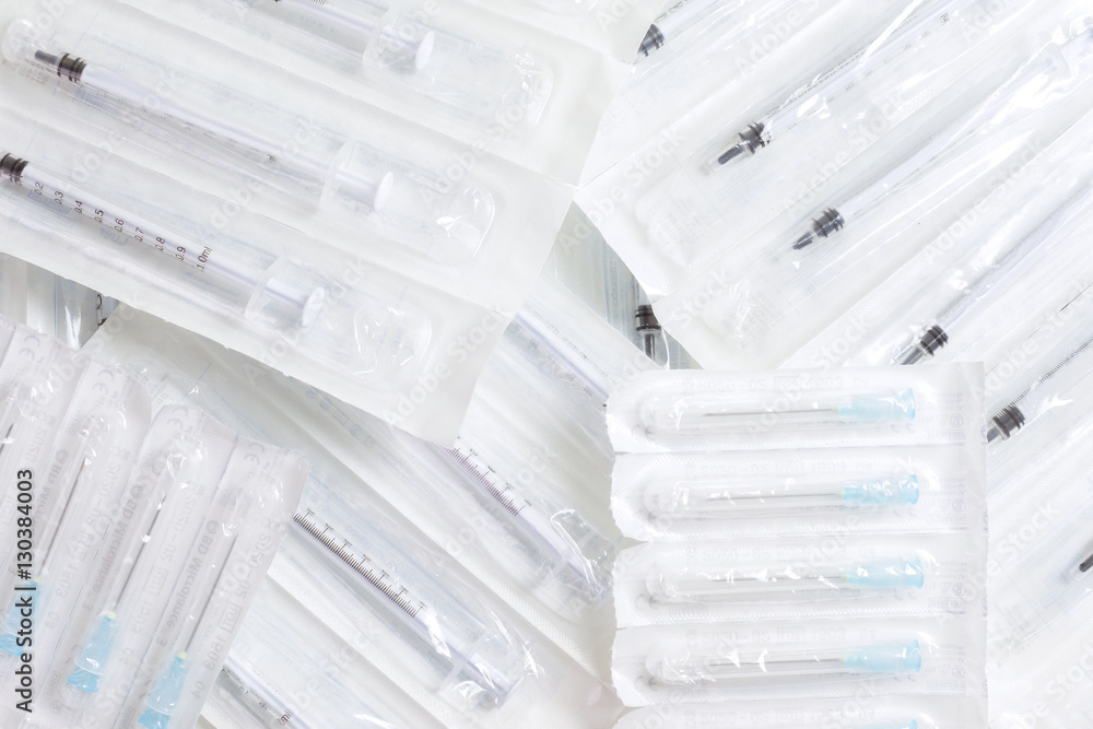 New syringes and needles lie on the surface, packed in bags. New syringes and needles lie on the surface, packed in bags.