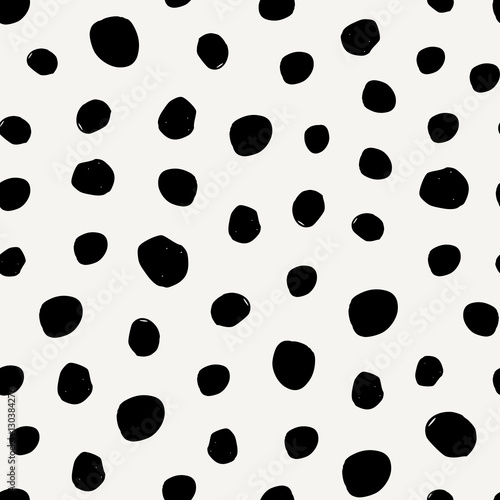 Seamless pattern with irregular dots in black on cream background.