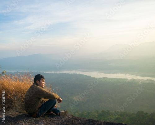 A young man on a cliff with misty and foggy