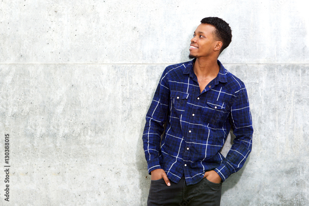 smiling relaxed african american man standing against wall smiling relaxed african american man standing against wall