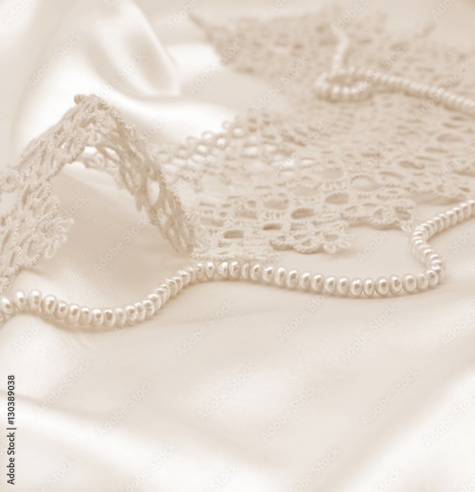 Fototapeta premium Smooth elegant golden silk or satin with pearls and lace as wedd