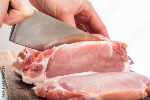 Cutting raw meat on wooden board