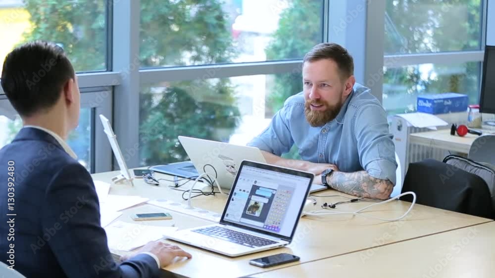 business men talking in an office with laptops. business men talking in an office with laptops.