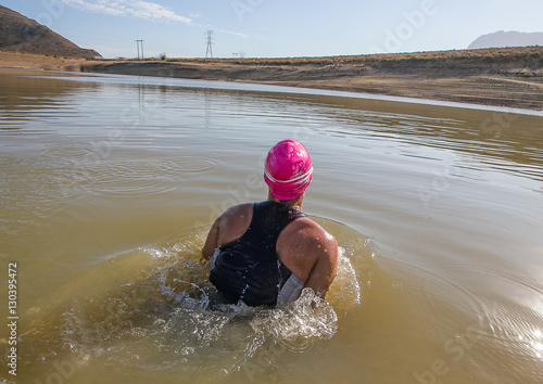 Female triathlete about to start a triathlon race in a dam photo