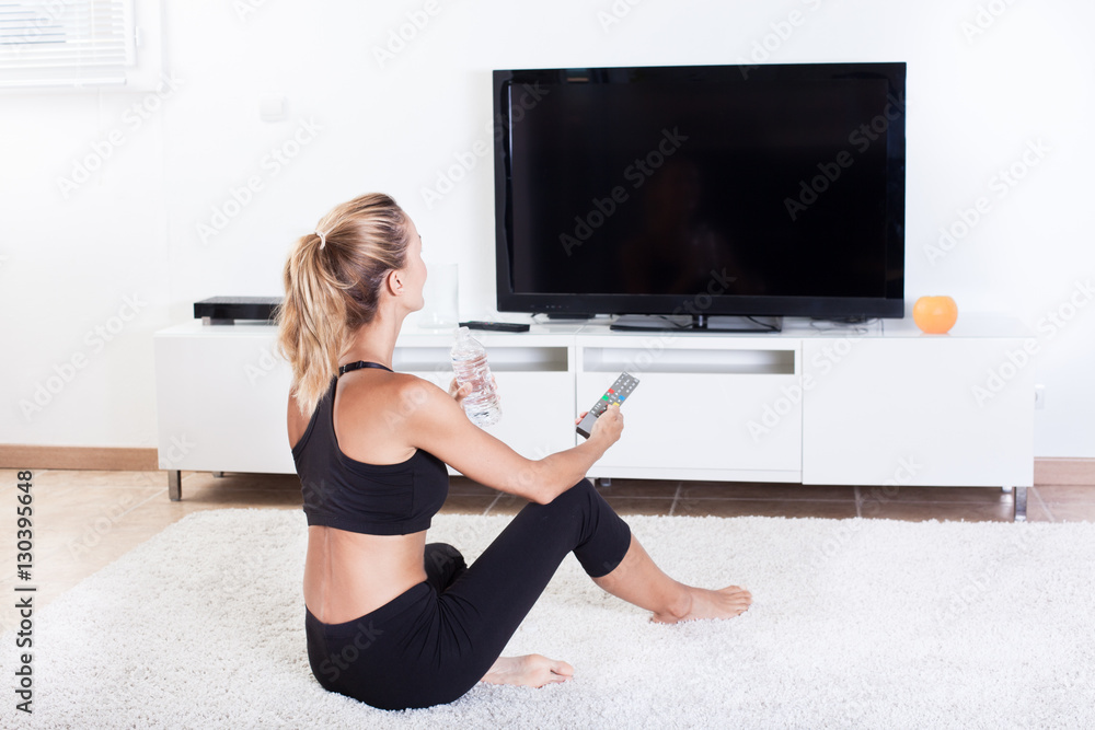 femme en tenue de sport devant sa télévision femme en tenue de sport devant sa télévision