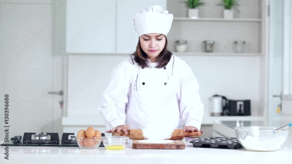 Young woman cooking cake in the kitchen and makes a flour dough with wooden roll
Young woman cooking cake in the kitchen and makes a flour dough with wooden roll