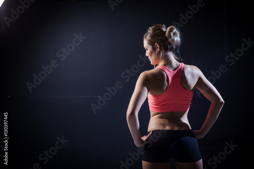 Beautiful female fitness model holding a towel/weights