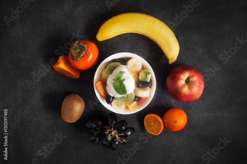 Bowl of healthy fresh fruit salad on black chalkboard