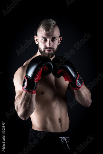 Male Athlete boxer punching a punching bag with dramatic edgy li © Dewald