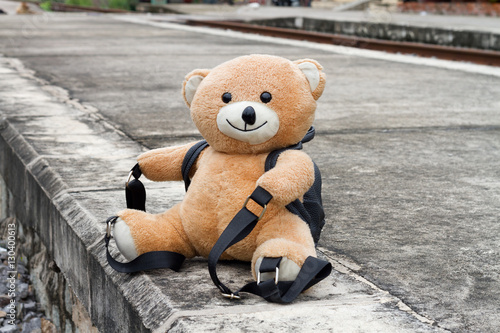 The teddy bear alone in railway station.