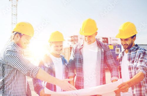 group of builders with tablet pc and blueprint