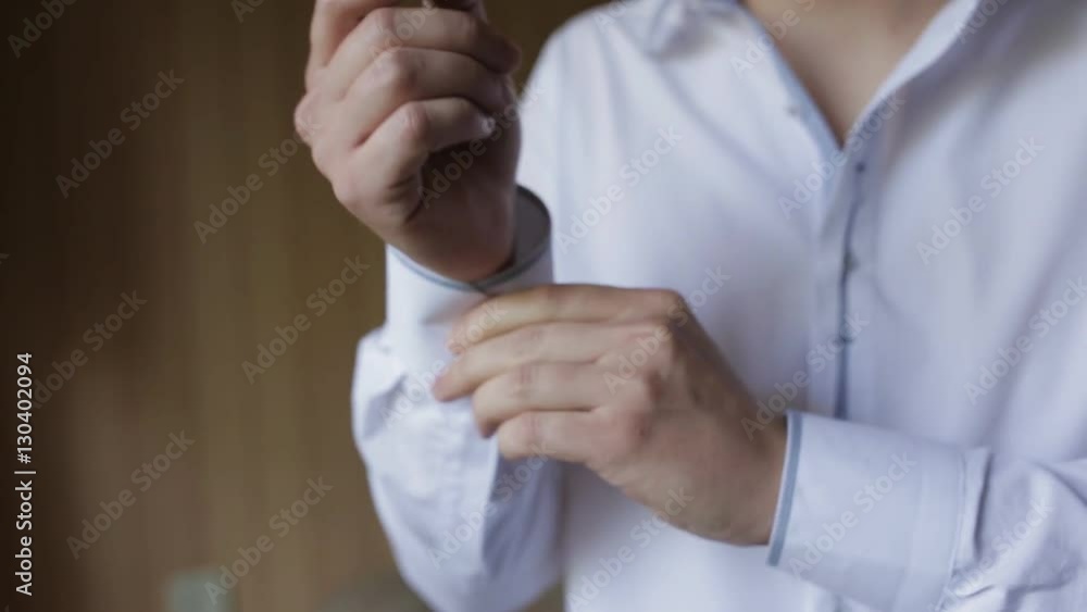 man buttoning his shirt sleeves. Close up man buttoning his shirt sleeves. Close up