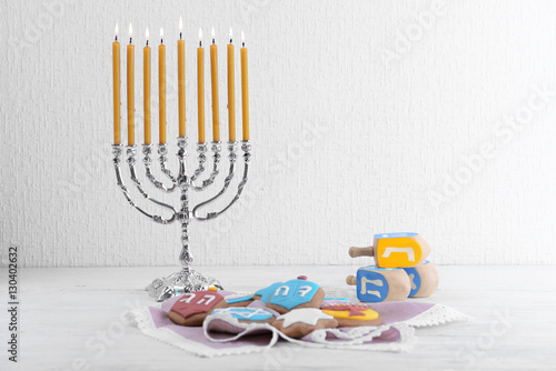 Beautiful composition for Hanukkah on wooden table against textured wall