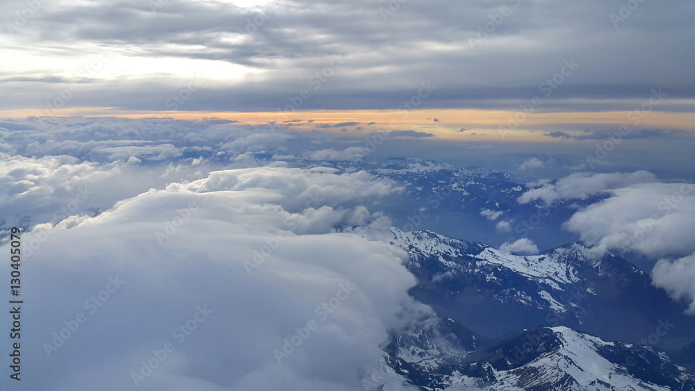 Top view on the Alps, covered with snow and clouds