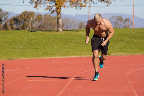 Male Athlete sprinting on a tartan athletics track on a bright s © Dewald