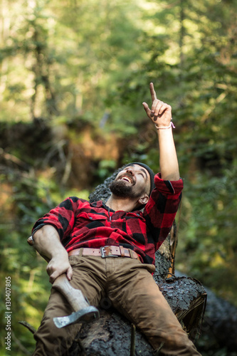portrait of a man - lumberjack with an ax in the forest, side view
