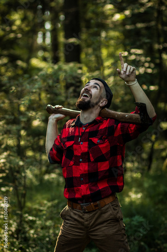 portrait of a man - lumberjack with an ax in the forest, side view