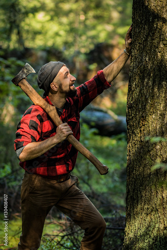portrait of a man - lumberjack with an ax in the forest, side view