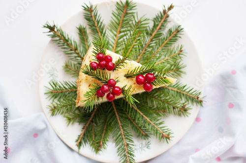 cake decorated Christmas tree branches and berries on a background of the Christmas tree